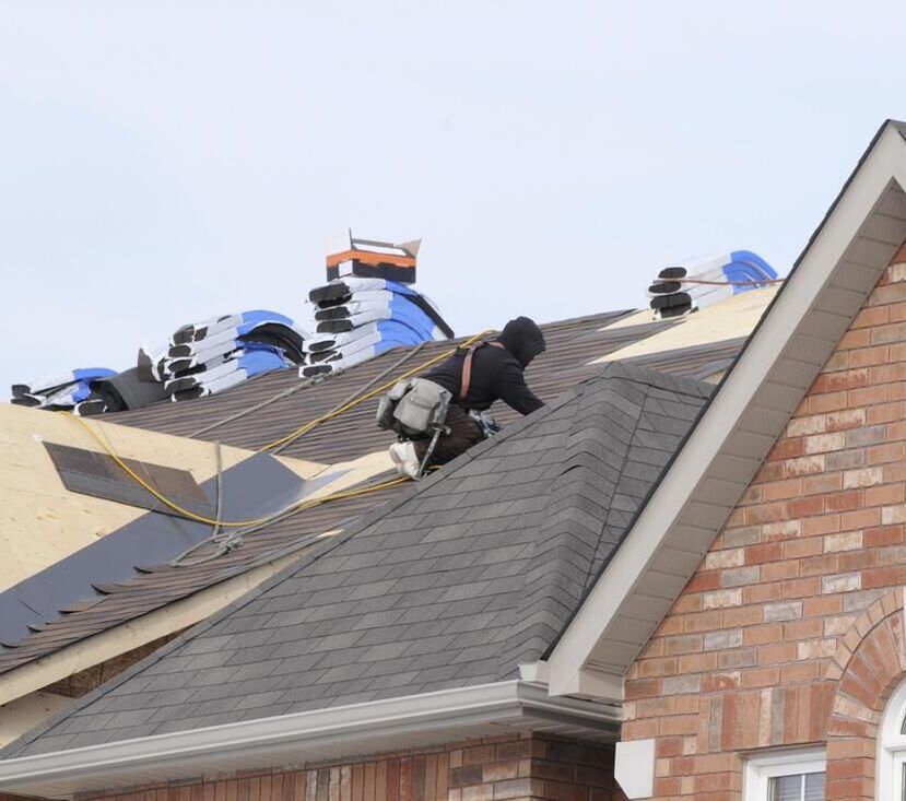Several men with roofing tools performing a residential roofing project in Elgin IL